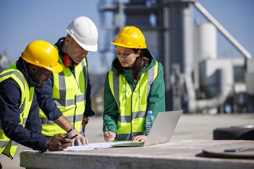 Image showing three people on a construction site planning something