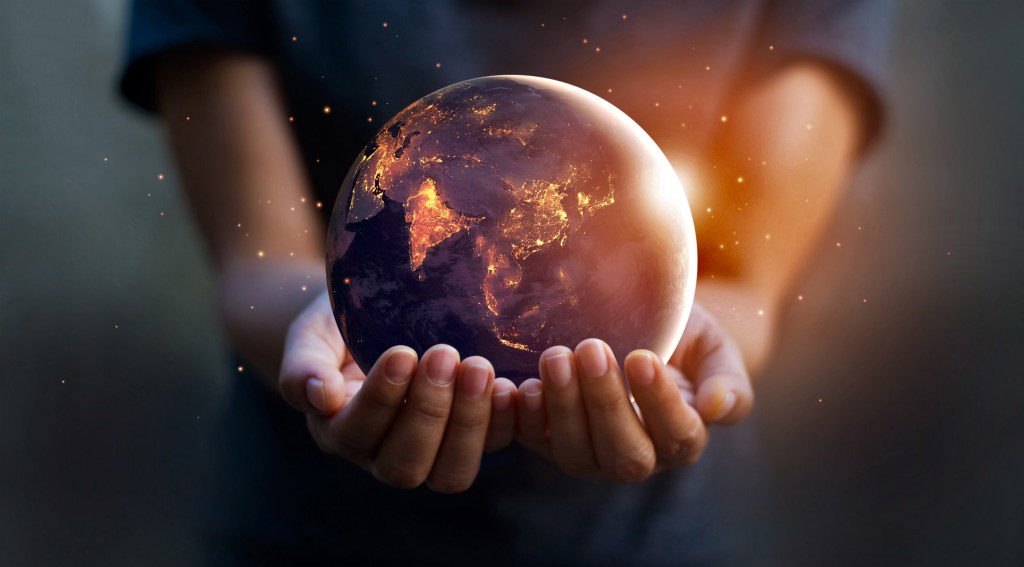 Hands holding a globe symbolizing industrial heat around the world and the energy transition. 